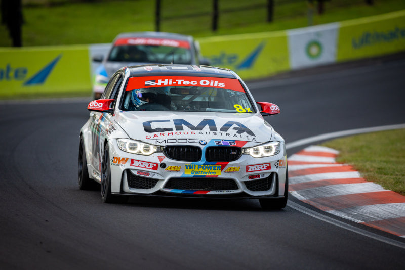 Performance race car on track with branding