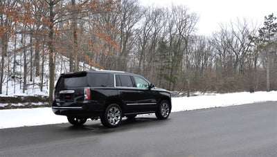 Corsa 2015-2020 GMC Yukon Denali 6.2L V8 Single Side Exit Cat-Back Exhaust w/ Polished Black Tips driving on a snowy road