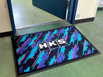 HKS Door Mat - Oil Color for performance car parts enthusiasts, available at DTX Performance, featuring vibrant racing-inspired design.