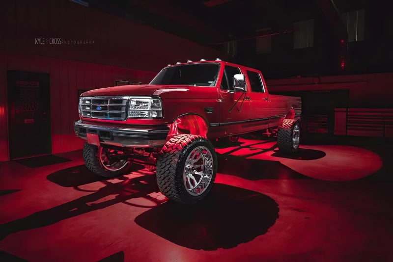 Lifted truck with Oracle Bluetooth + RF Underbody Rock Light Kit - 8 PCS - ColorSHIFT showcasing performance car parts lighting.