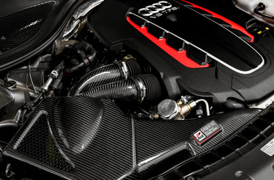 AWE Tuning Audi C7 S6 / S7 4.0T S-FLO Carbon Intake V2 in a performance car engine bay, featuring high-performance auto parts from DTX Performance.