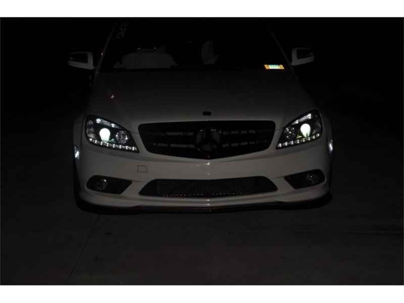 Spyder Mercedes Benz C-Class 08-11 Projector Headlights Halogen - DRL Blk installed on a vehicle at night, enhancing visibility.