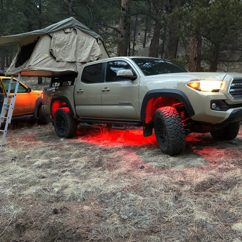 Truck with Oracle Bluetooth + RF Underbody Rock Light Kit - 8 PCS - ColorSHIFT illuminating ground in forest setting