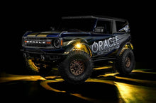 Load image into Gallery viewer, Oracle Underbody RGB+W Wheel Well Rock Light Kit - 4 PCS - ColorSHIFT on an off-road vehicle, showcasing vibrant lighting.