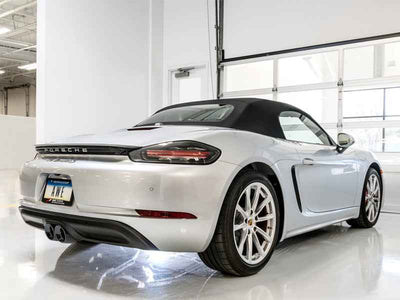 AWE Tuning Porsche 718 Boxster / Cayman Track Edition Exhaust - Diamond Black Tips showcased in a garage with high performance auto parts.