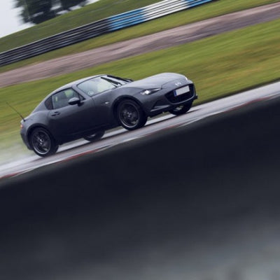 Ohlins 15-24 Mazda Miata (ND) Road & Track Coilover System in action on wet race track, performance car parts by DTX Performance