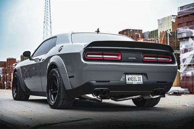 Rear view of a high-performance grey Dodge Challenger with custom wheels and dual exhaust, showcasing automotive tuning and upgrades.