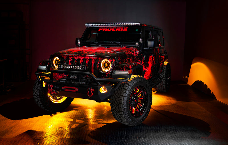 Jeep equipped with Oracle Bluetooth + RF Underbody Rock Light Kit - 8 PCS - ColorSHIFT glowing in garage, showcases off-road LED lights.