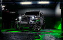 Load image into Gallery viewer, Oracle Bluetooth + RF Underbody Rock Light Kit illuminating off-road vehicle in dark garage, showcasing ColorSHIFT lighting.