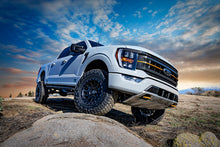 Load image into Gallery viewer, White Ford F150 with ICON 21-23 Ford F150 Tremor 2.5-3in 2.5 Series VS RR CDCV Coilover Kit on rocky terrain at sunset