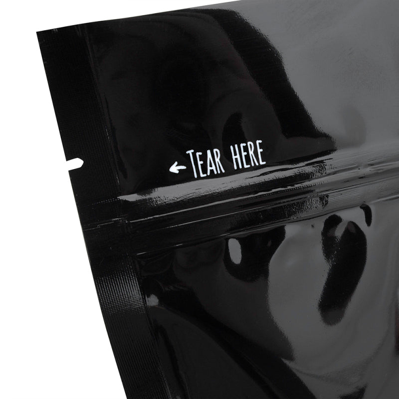 Close-up of a black package with 'Tear Here' mark