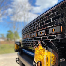 Load image into Gallery viewer, Close-up of a black vehicle grille with illuminated ORACLE Lighting Universal LED letter badges, emphasizing high-end performance car parts.