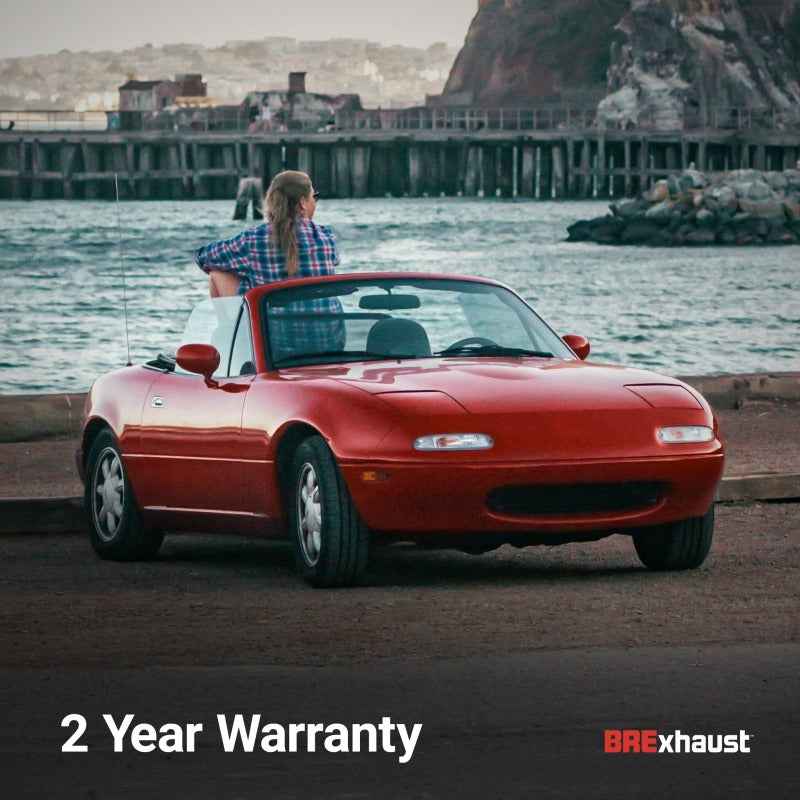 Red convertible car with 2 year warranty on BRE exhaust system by the sea.