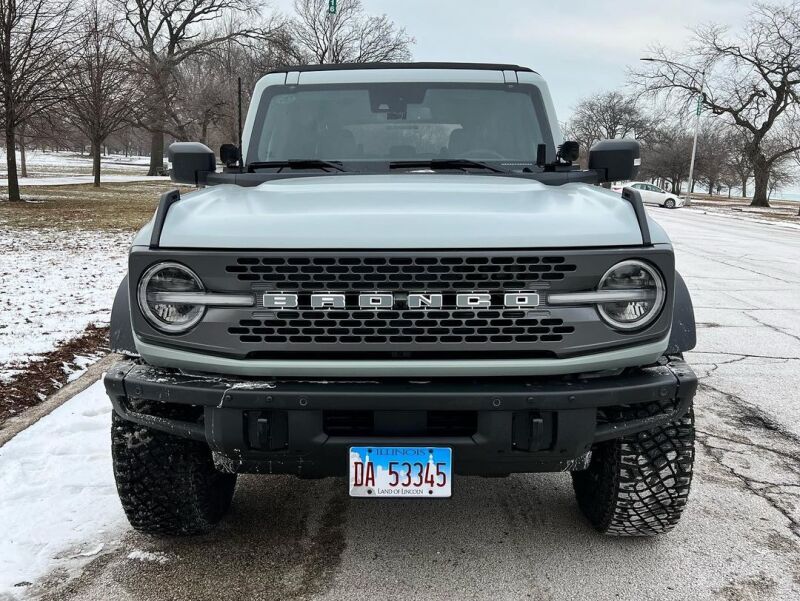 Front view of a gray Ford Bronco on a snowy road.