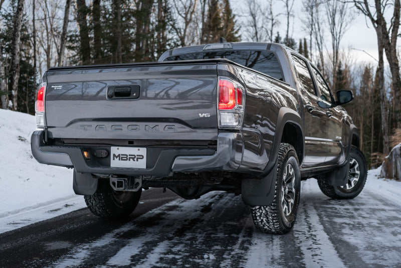 MBRP 2016 Toyota Tacoma 3.5L Cat Back Turn Down Style T409 Exhaust System behind a truck in snowy forest