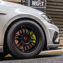 Load image into Gallery viewer, High-performance car with racing wheels and brake upgrades on an urban street at night, showcasing sleek design and advanced tuning.