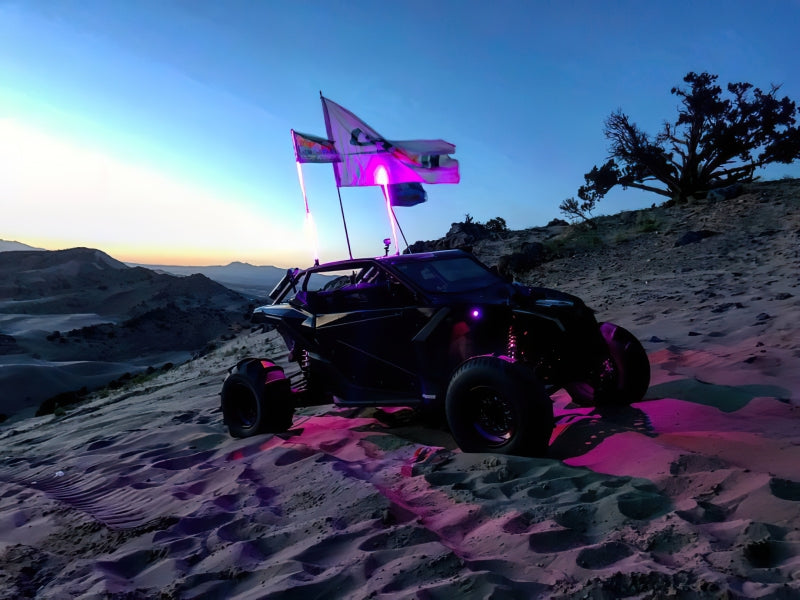 Oracle Bluetooth + RF Underbody Rock Light Kit illuminating off-road vehicle at sunset, perfect for performance car parts enthusiasts.