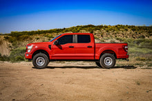 Load image into Gallery viewer, Red Ford truck displaying ICON 21-23 Ford F150 Tremor 2.5-3in 2.5 Series VS RR CDCV Coilover Kit on desert terrain.