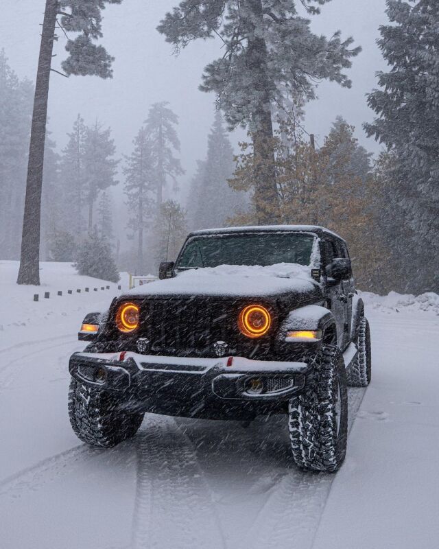 Jeep Wrangler with Oracle LED headlights off-road in snow; showcasing enhancements with Oracle Jeep Wrangler JL/Gladiator JT 7in. LED Headlights